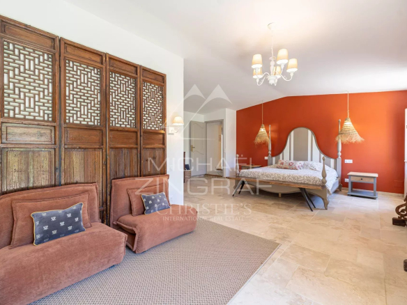Chambre d'un mas en pierre avec décoration chaleureuse et mobilier en bois.