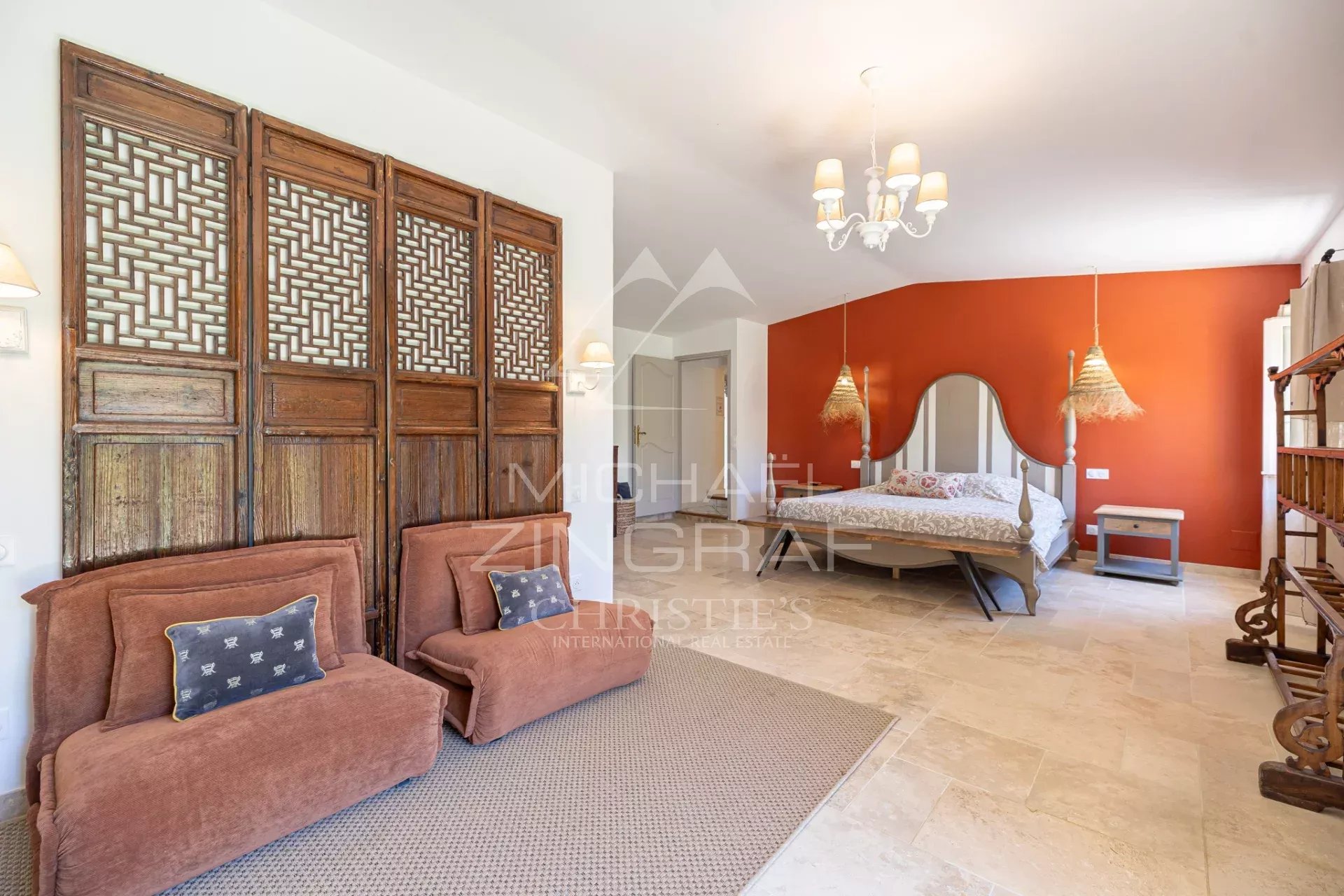 Chambre d'un mas en pierre avec décoration chaleureuse et mobilier en bois.