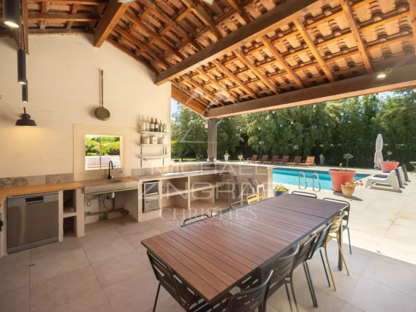 Cuisine extérieure avec vue sur la piscine dans un mas en pierre à Cavaillon