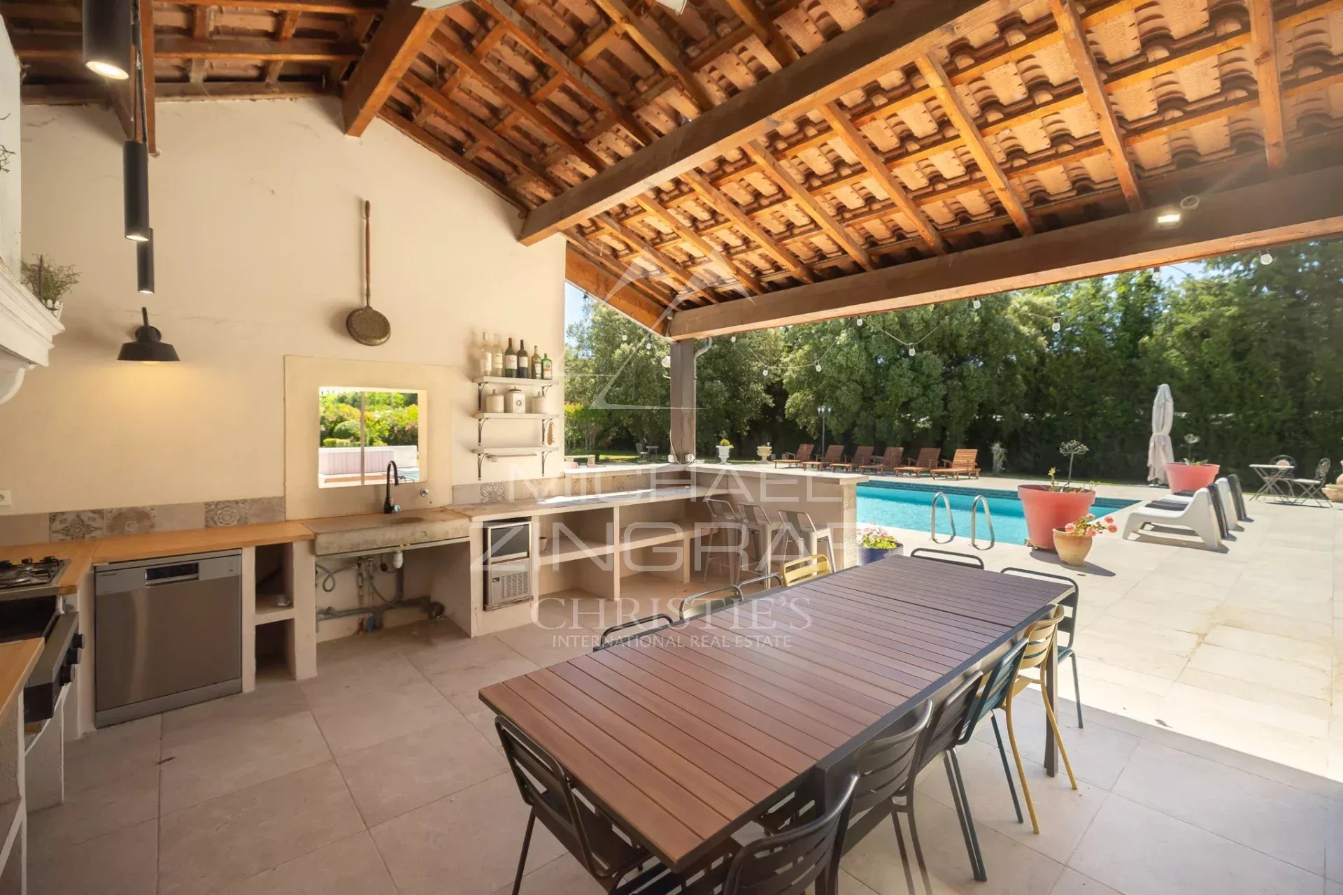 Cuisine extérieure avec vue sur la piscine dans un mas en pierre à Cavaillon