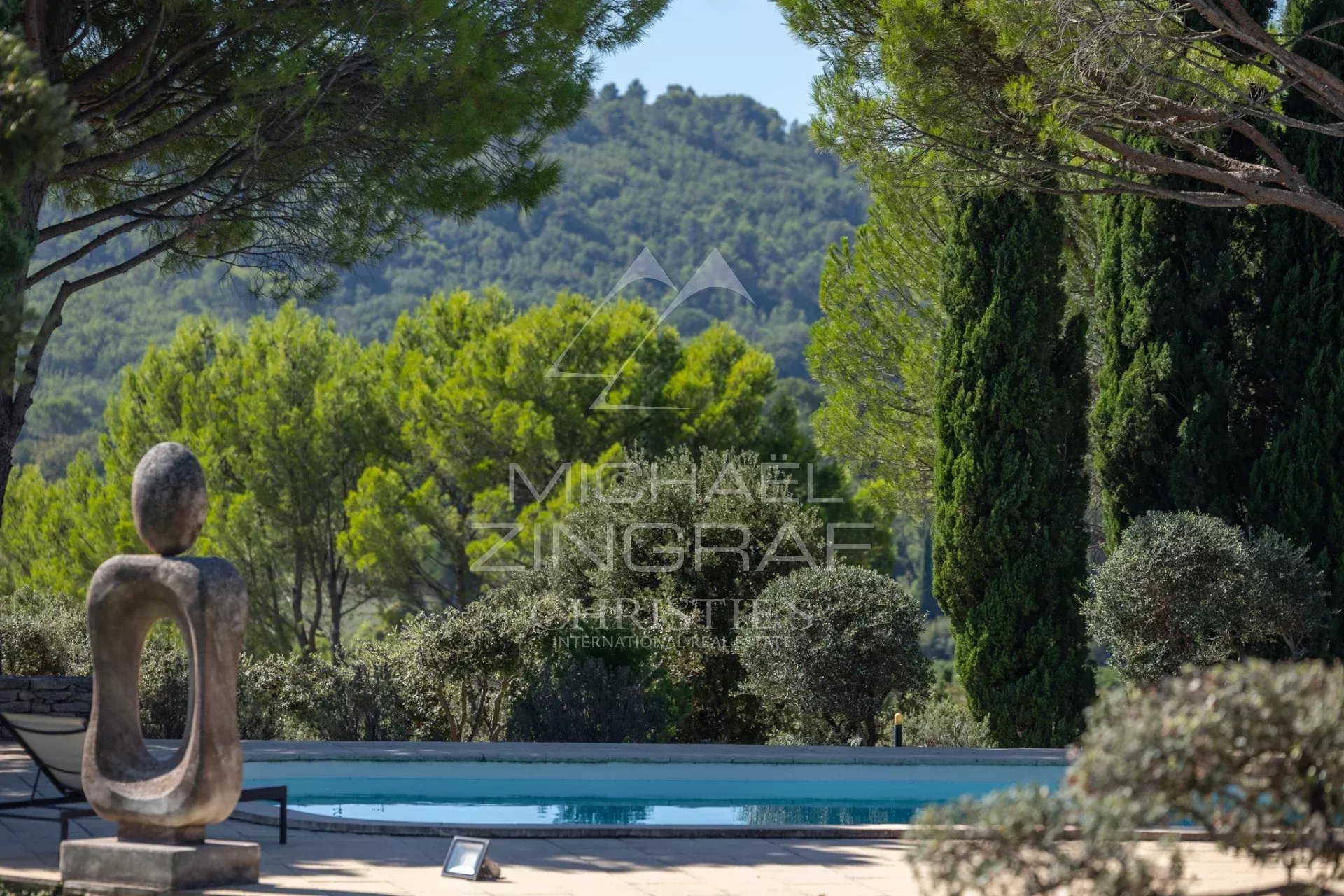 Maison d’architecte à Gordes Vue d'une maison d'architecte avec piscine et sculptures, entourée de verdure à Gordes.