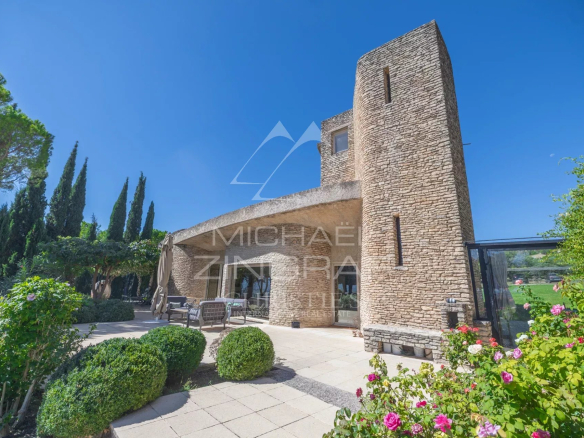 Maison d'architecte à Gordes, avec façade en pierre et jardin paysager.