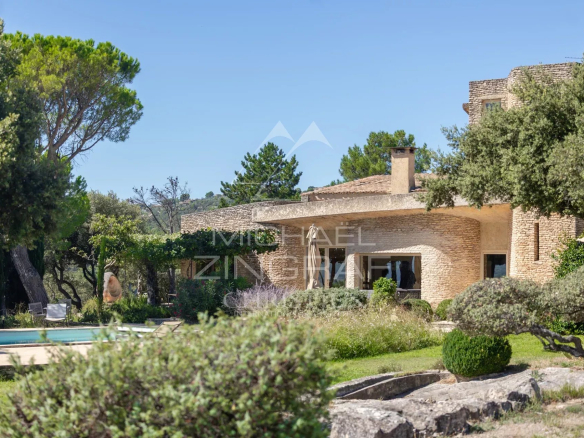 Maison d'architecte à Gordes, entourée de verdure, avec piscine et éléments architecturaux distinctifs.