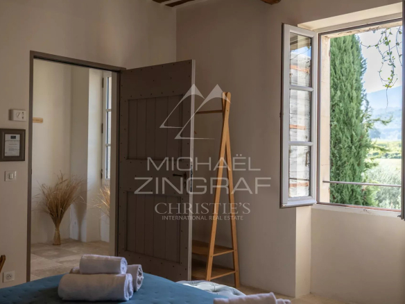 Room in a Provençal farmhouse with a view of the Luberon, windows open.