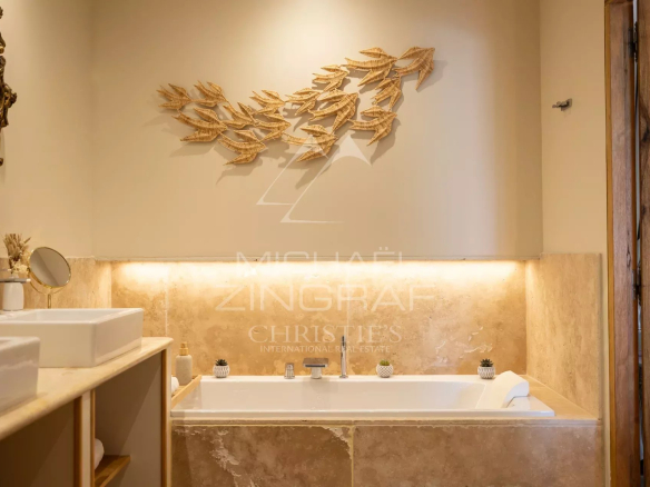 Bathroom with bathtub and wooden decor, soft lighting.