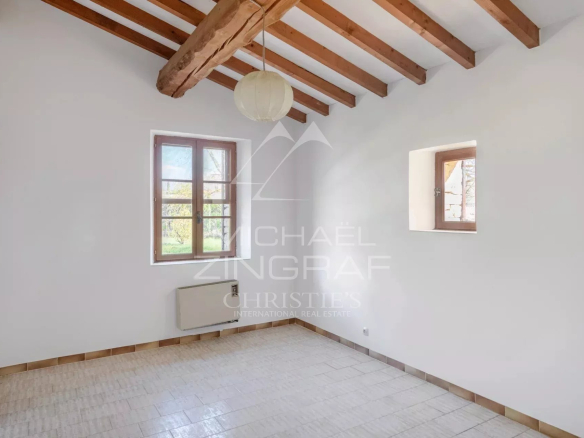 Interior of a house to be renovated with exposed beams and windows, located in Gordes.