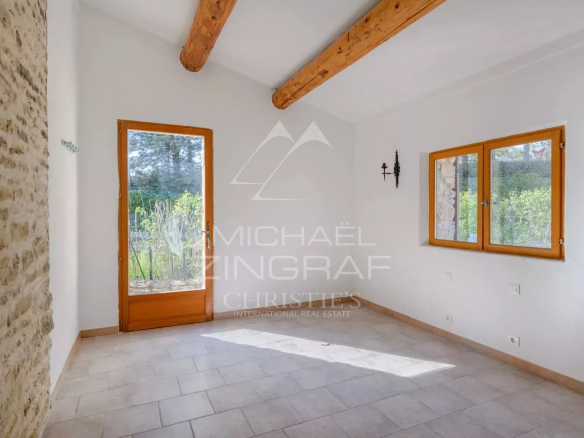Interior of a house to be renovated with stone walls and wooden beams.