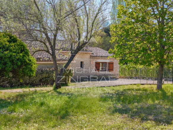 Stone house to renovate on a 3,200 m² plot in Gordes, surrounded by trees and greenery.