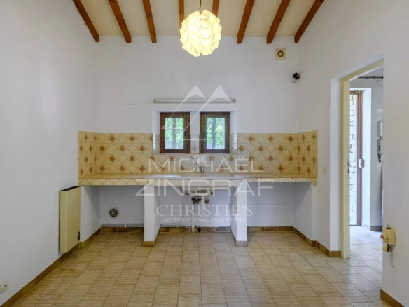 Interior of a house to be renovated in Gordes, with light walls and a tiled floor.