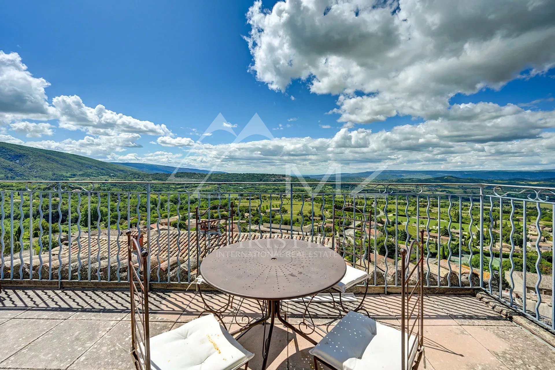 Vue panoramique sur le Luberon Vue panoramique depuis une terrasse avec table et chaises, sur le Luberon à Bonnieux.
