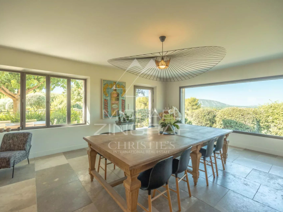 Salle à manger lumineuse avec vue sur le jardin et la plaine du Luberon.