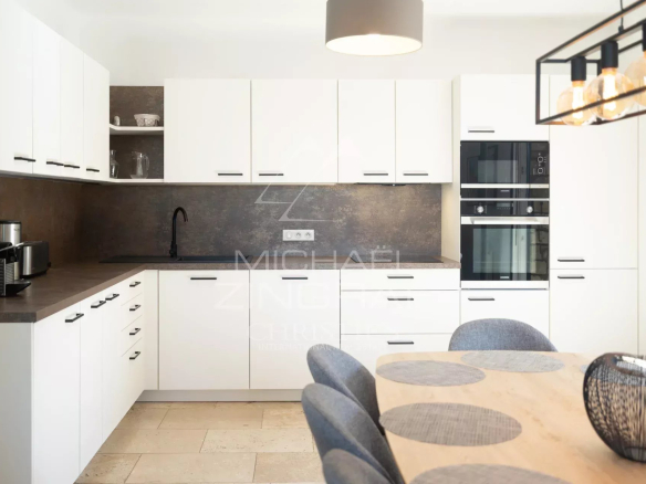 Cuisine moderne et lumineuse d'une maison en pierre à Roussillon, avec table à manger et équipements contemporains.