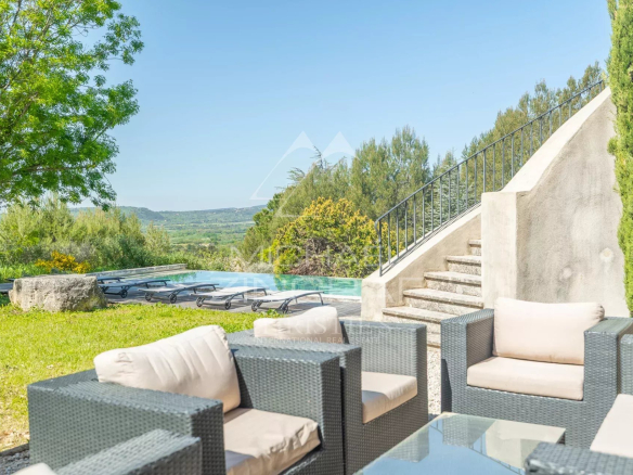 Terrasse avec mobilier de jardin et piscine, vue sur la nature à Roussillon.