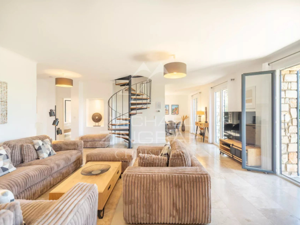 Intérieur d'une maison en pierre à Roussillon avec un salon spacieux et un escalier en colimaçon.