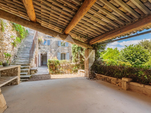 Covered terrace of a commercial premises with access to a garden in Ménerbes.