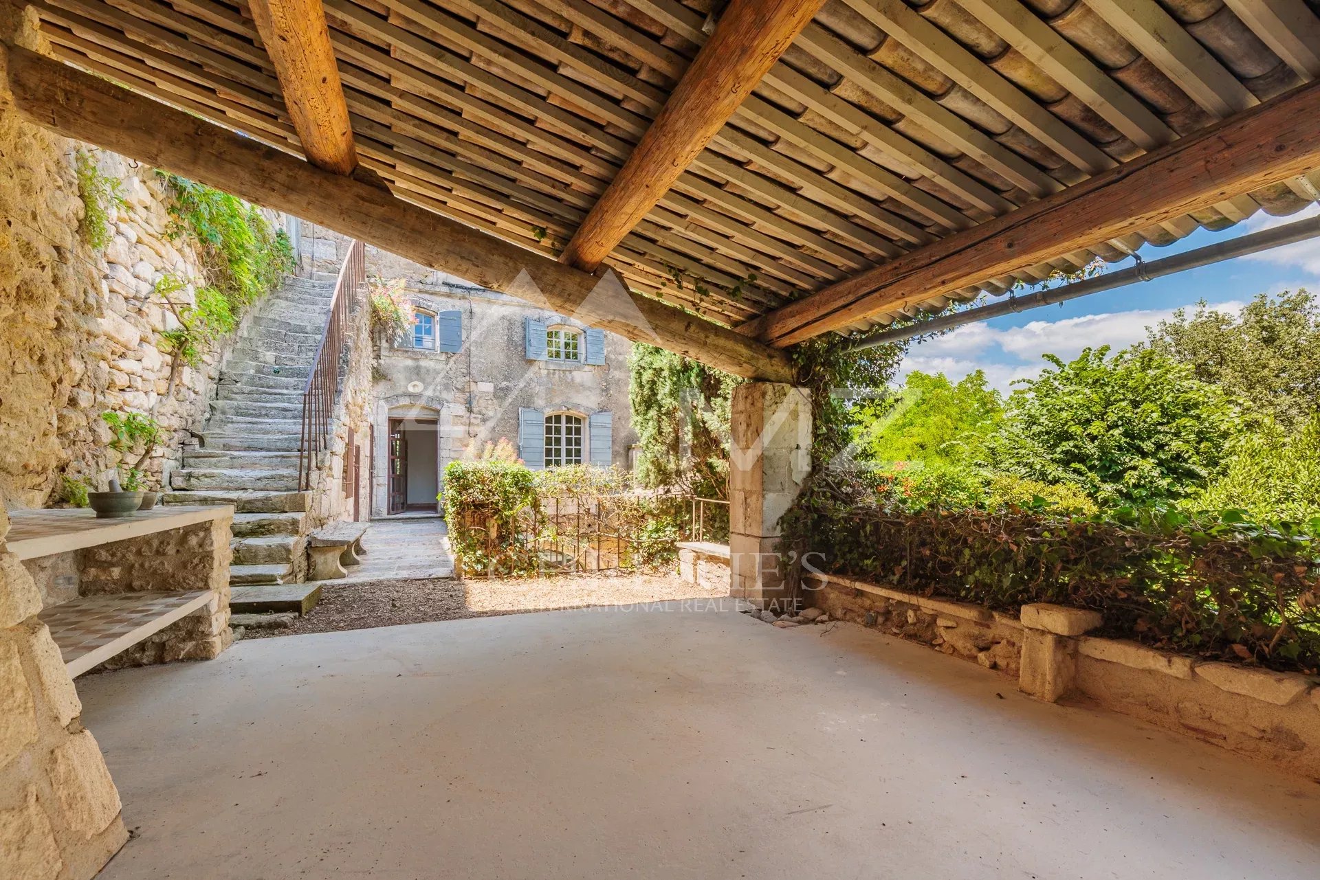 Covered terrace of a commercial premises with access to a garden in Ménerbes.