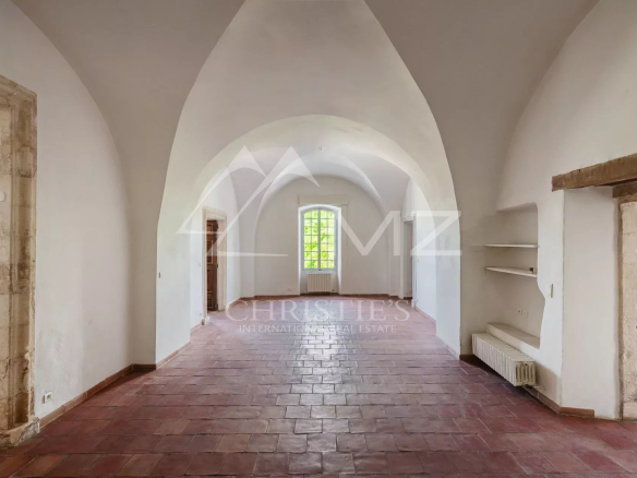 Interior of a renovated commercial space with stone walls and a vaulted ceiling in Ménerbes.