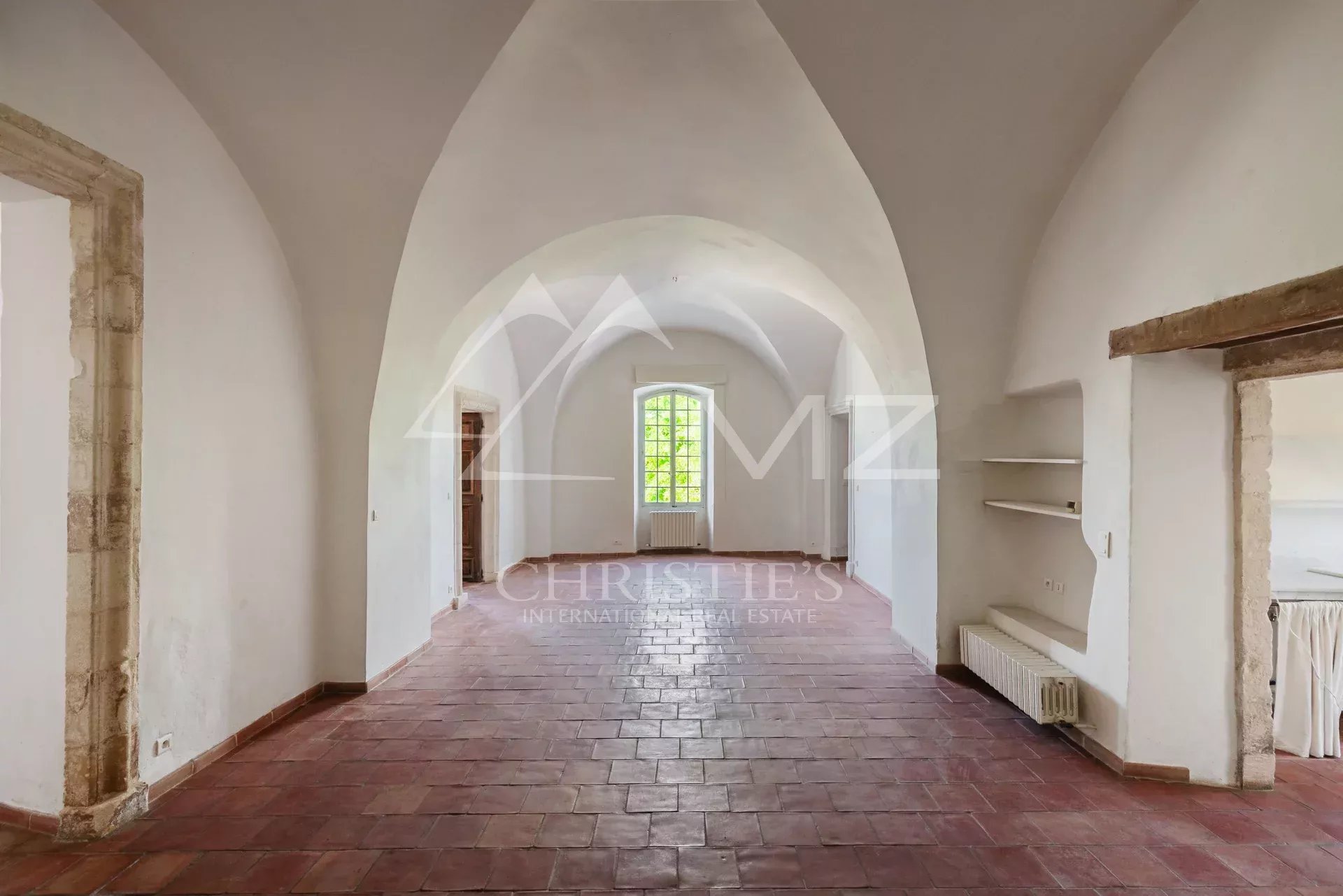 Interior of a renovated commercial space with stone walls and a vaulted ceiling in Ménerbes.