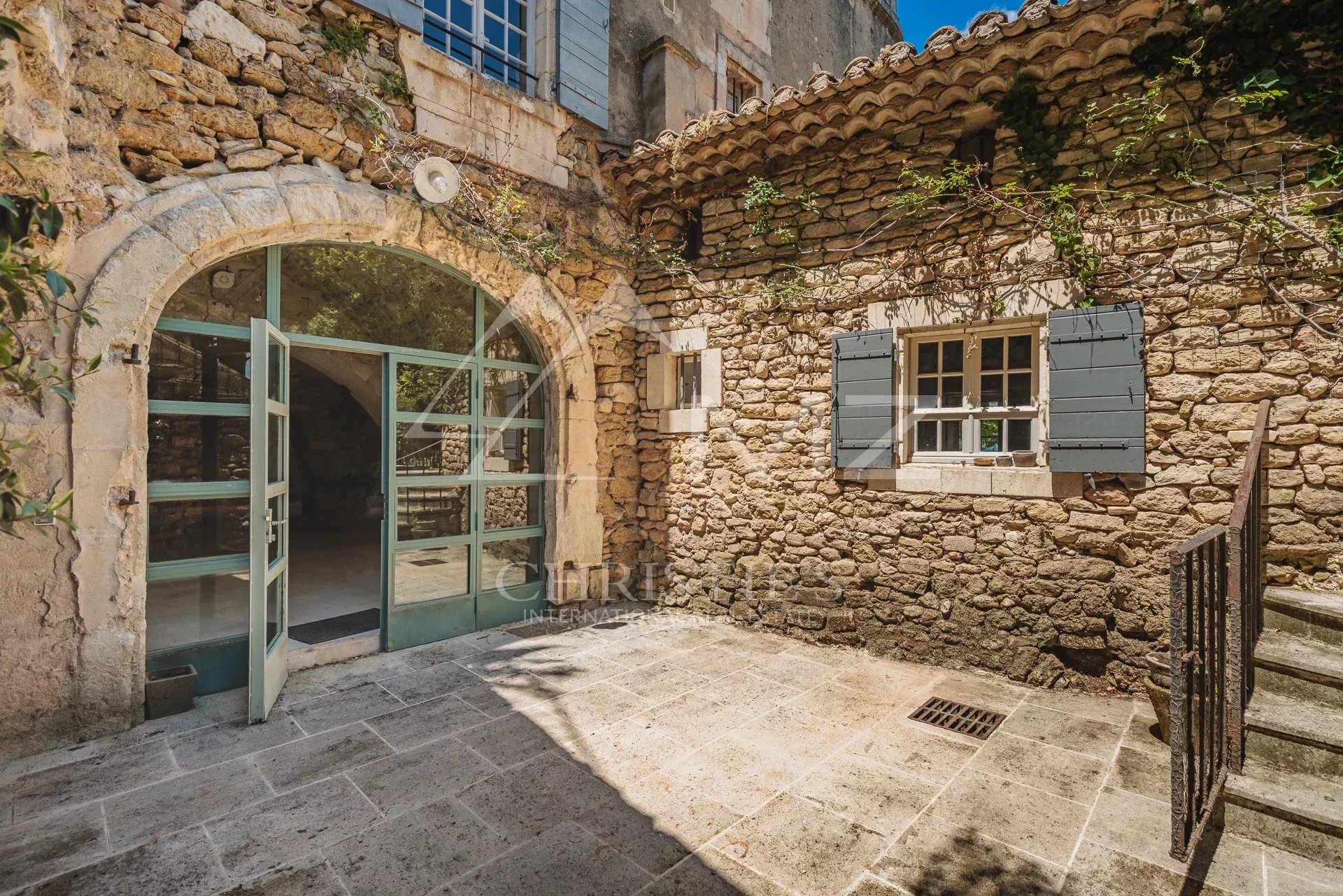 Entrance to a stone building with a commercial space and an apartment in Ménerbes.