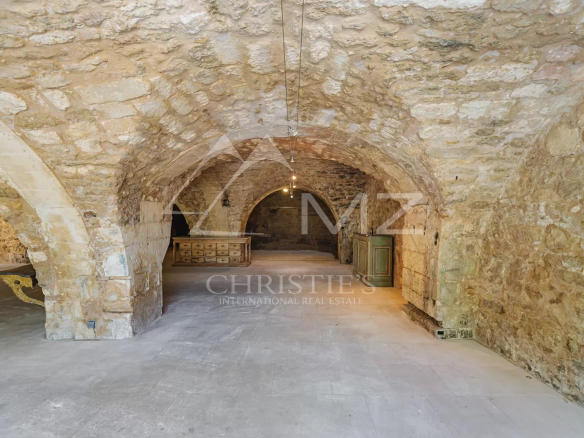 Interior of a commercial space with stone vaults in Ménerbes, empty and bright space.