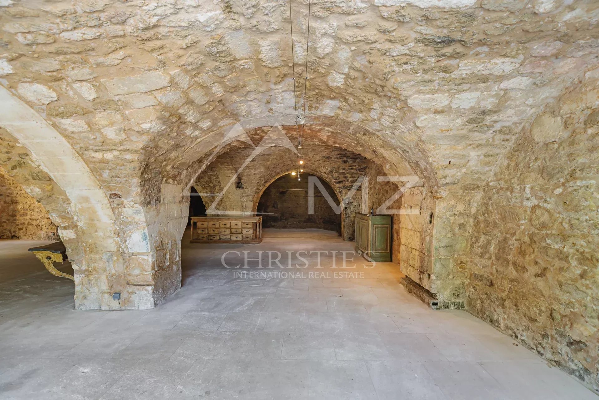 Interior of a commercial space with stone vaults in Ménerbes, empty and bright space.