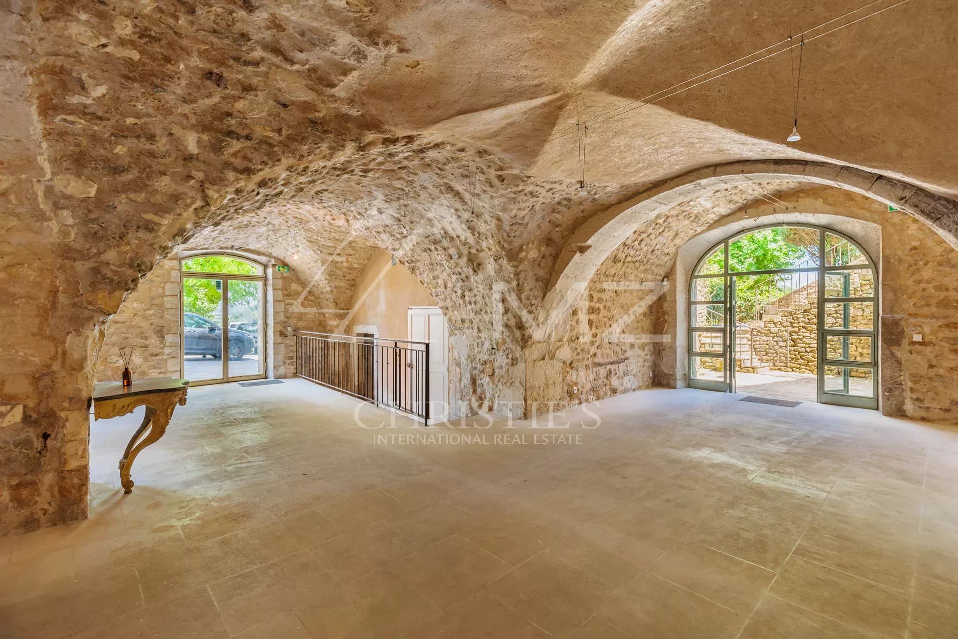 Interior of a commercial space with stone vaults and natural lighting in Ménerbes.