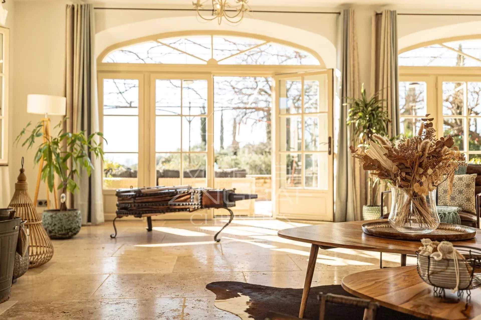 Intérieur d’une propriété à Saint-Saturnin-lès-Apt Intérieur d'une propriété provençale avec vue sur la campagne, décoré avec des plantes et du mobilier en bois.
