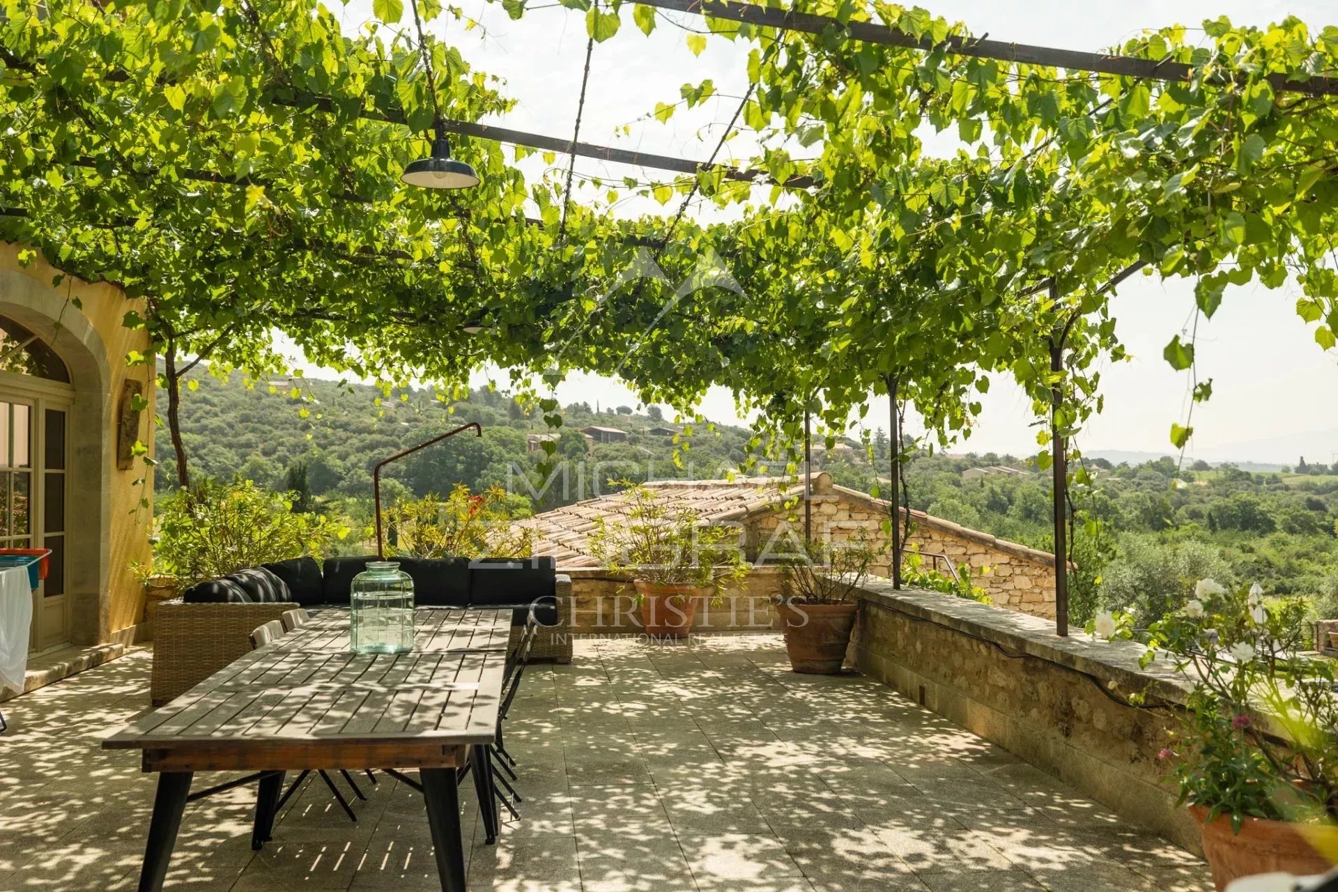 Terrasse avec vue panoramique à Saint-Saturnin-lès-Apt Terrasse ombragée avec des vignes et vue sur la campagne à Saint-Saturnin-lès-Apt.