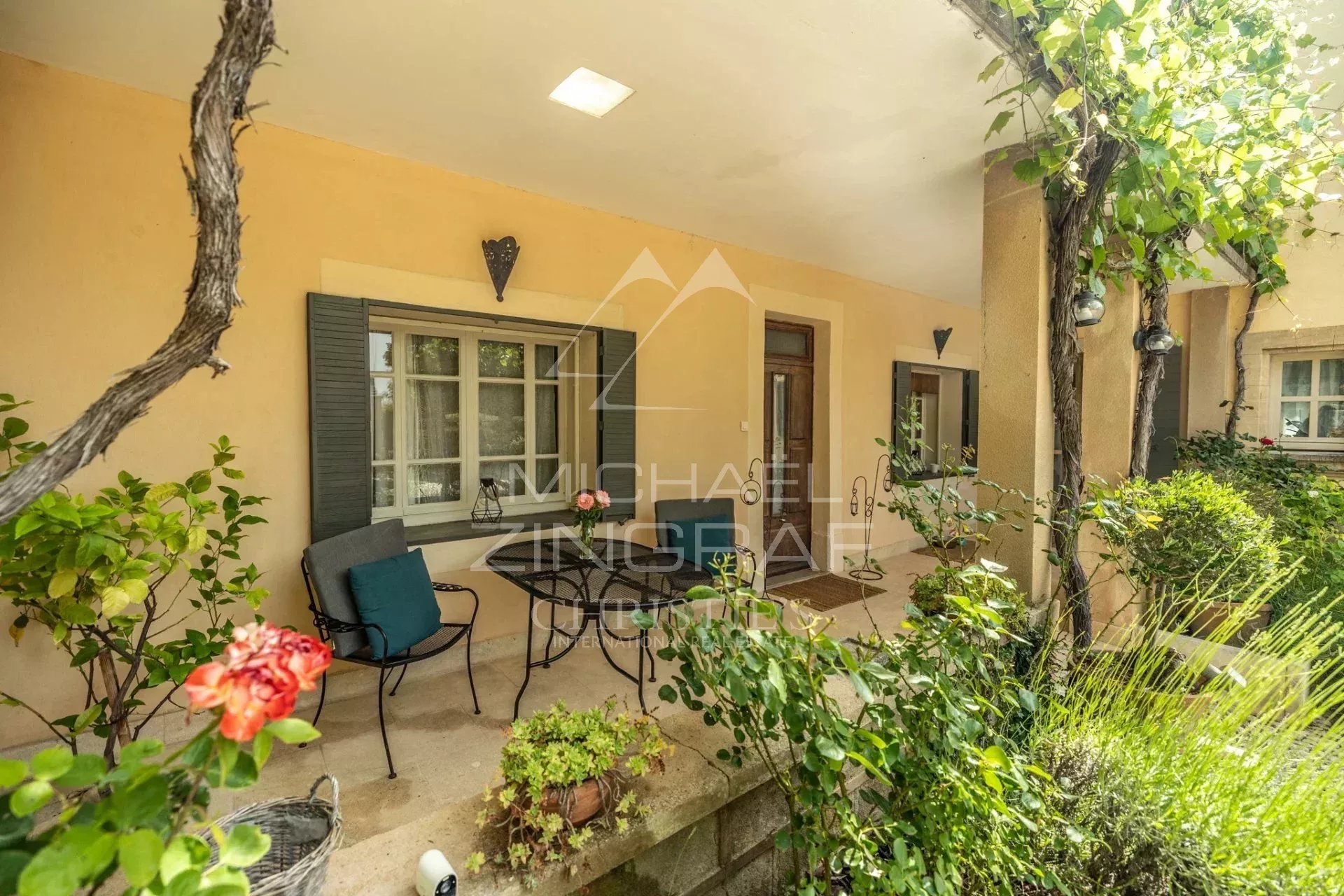 Terrasse d’une propriété à Saint-Saturnin-lès-Apt Terrasse d'une propriété provençale avec plantes et mobilier, vue sur le jardin.