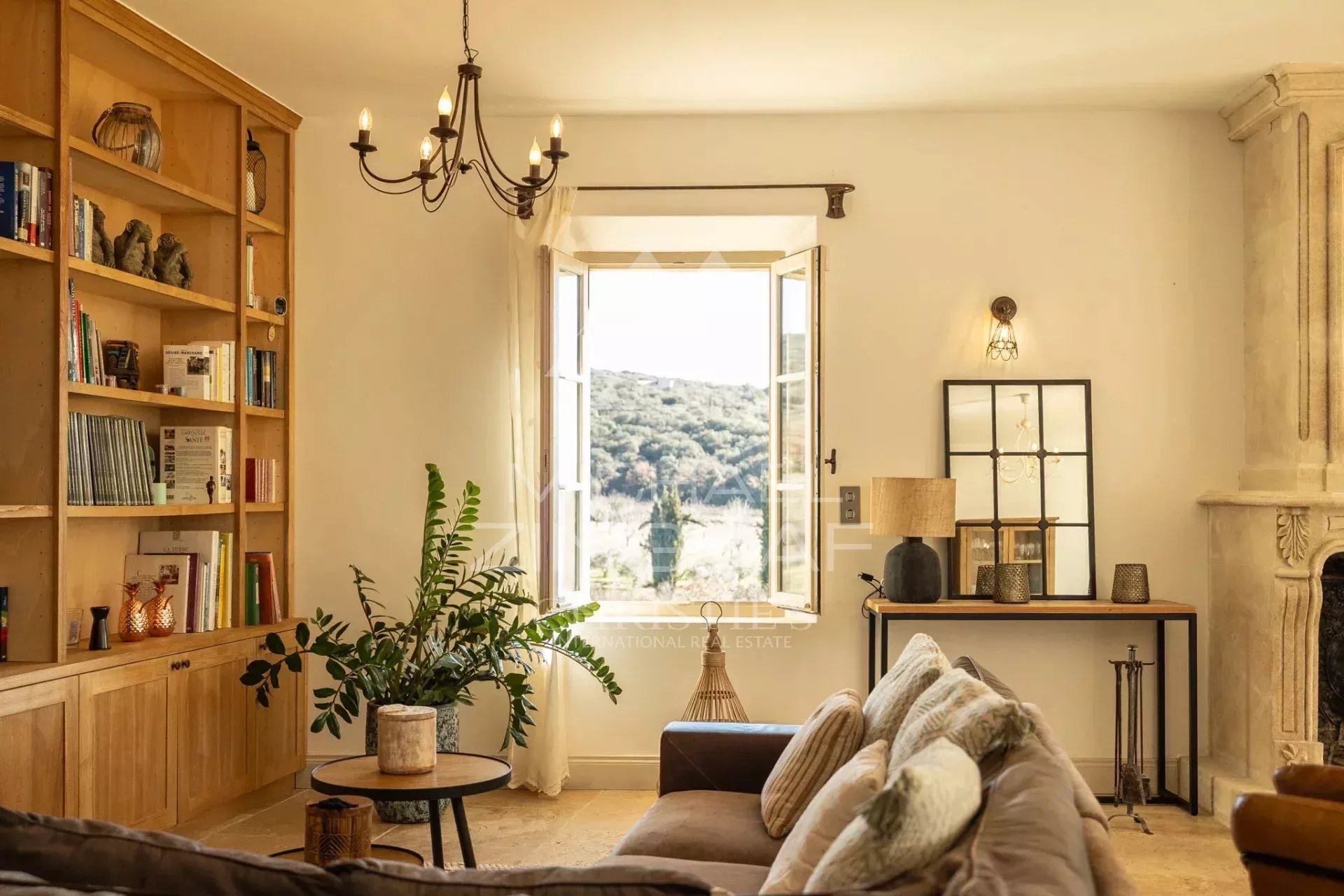 Salon d’une propriété à Saint-Saturnin-lès-Apt Intérieur d'une propriété provençale avec un salon lumineux et vue sur la campagne.