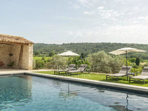 Piscine d'une propriété provençale avec vue sur la campagne et les collines environnantes.