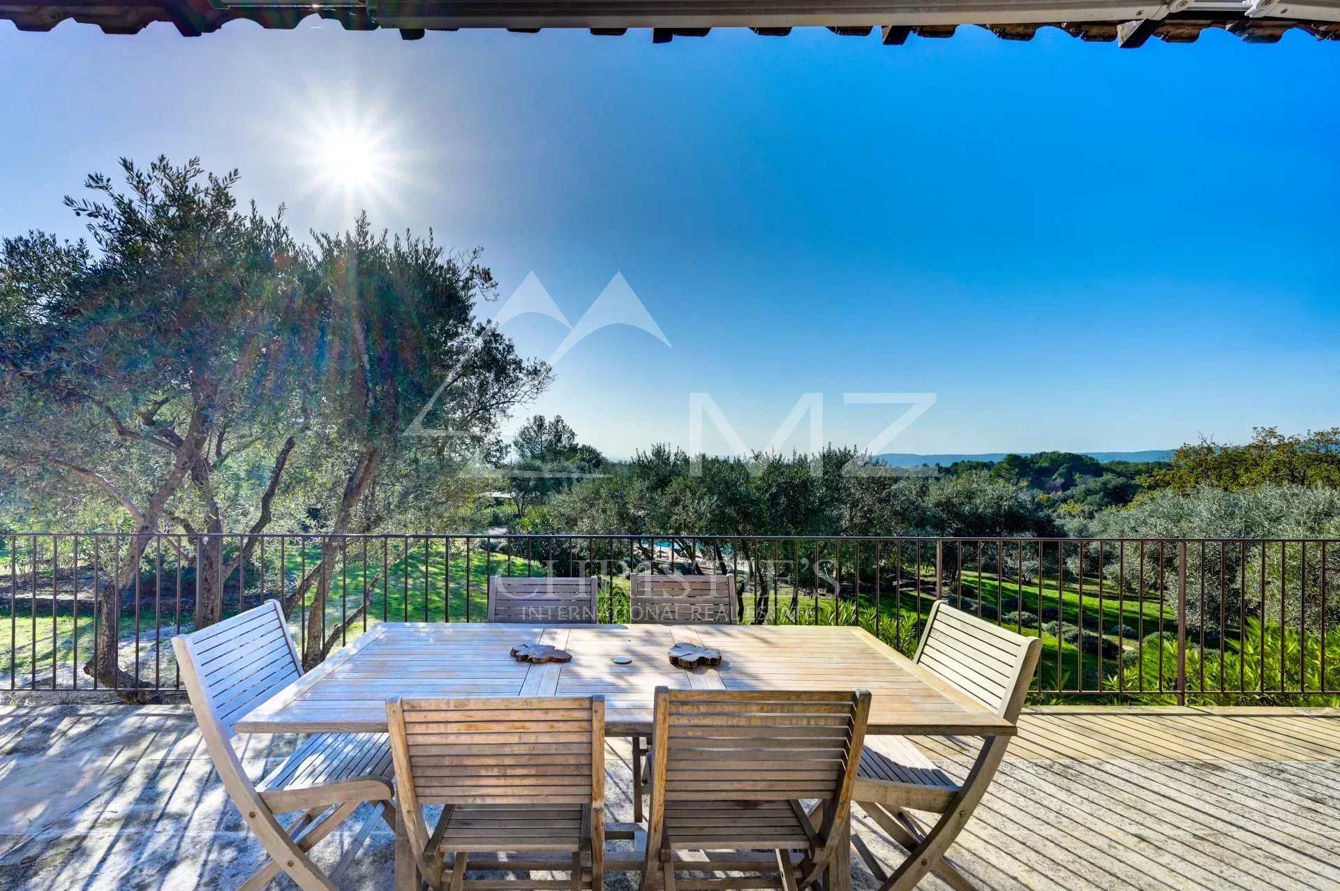 Maison en pierre avec vue à Gordes Terrasse en bois avec table et chaises, vue sur la campagne et les oliviers à Gordes.
