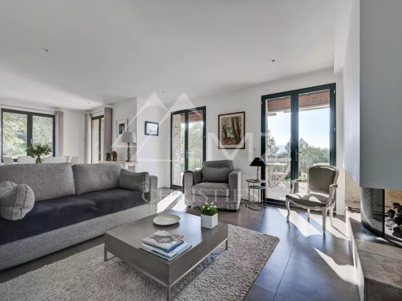 Intérieur d'une maison en pierre à Gordes avec salon lumineux et vue sur la campagne.
