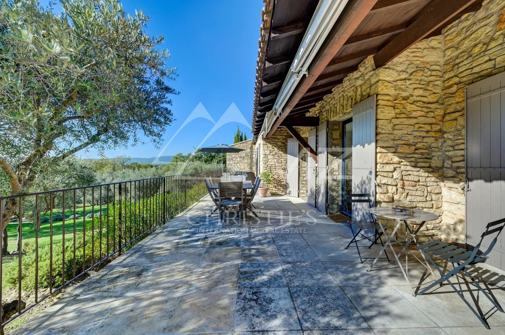 Terrasse avec vue à Gordes Terrasse d'une maison en pierre avec vue sur la campagne et mobilier extérieur à Gordes.