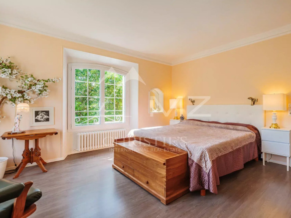 Chambre d'une maison avec lit, fenêtre et décor sobre.