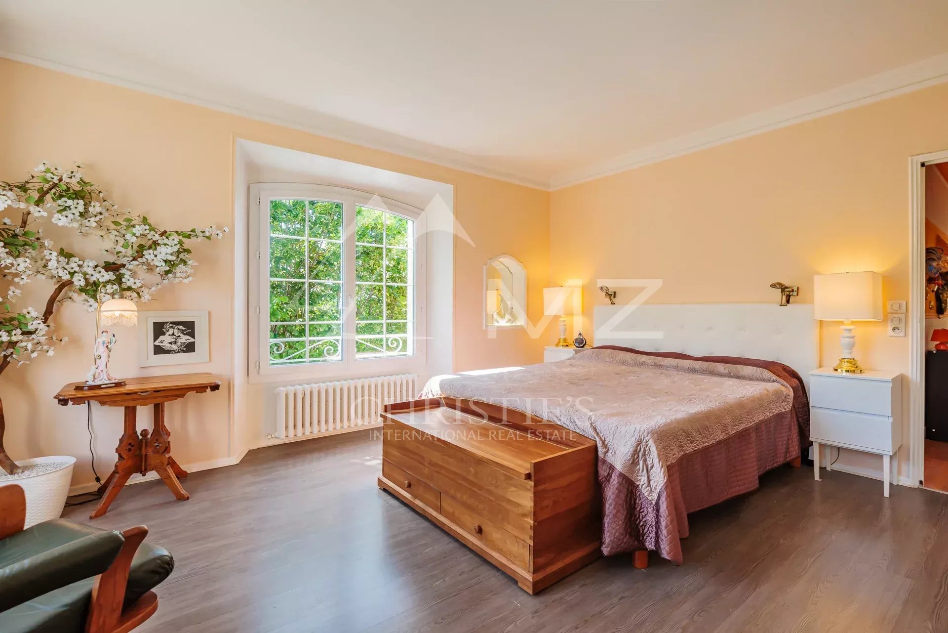 Chambre spacieuse dans une belle demeure Chambre d'une maison avec lit, fenêtre et décor sobre.