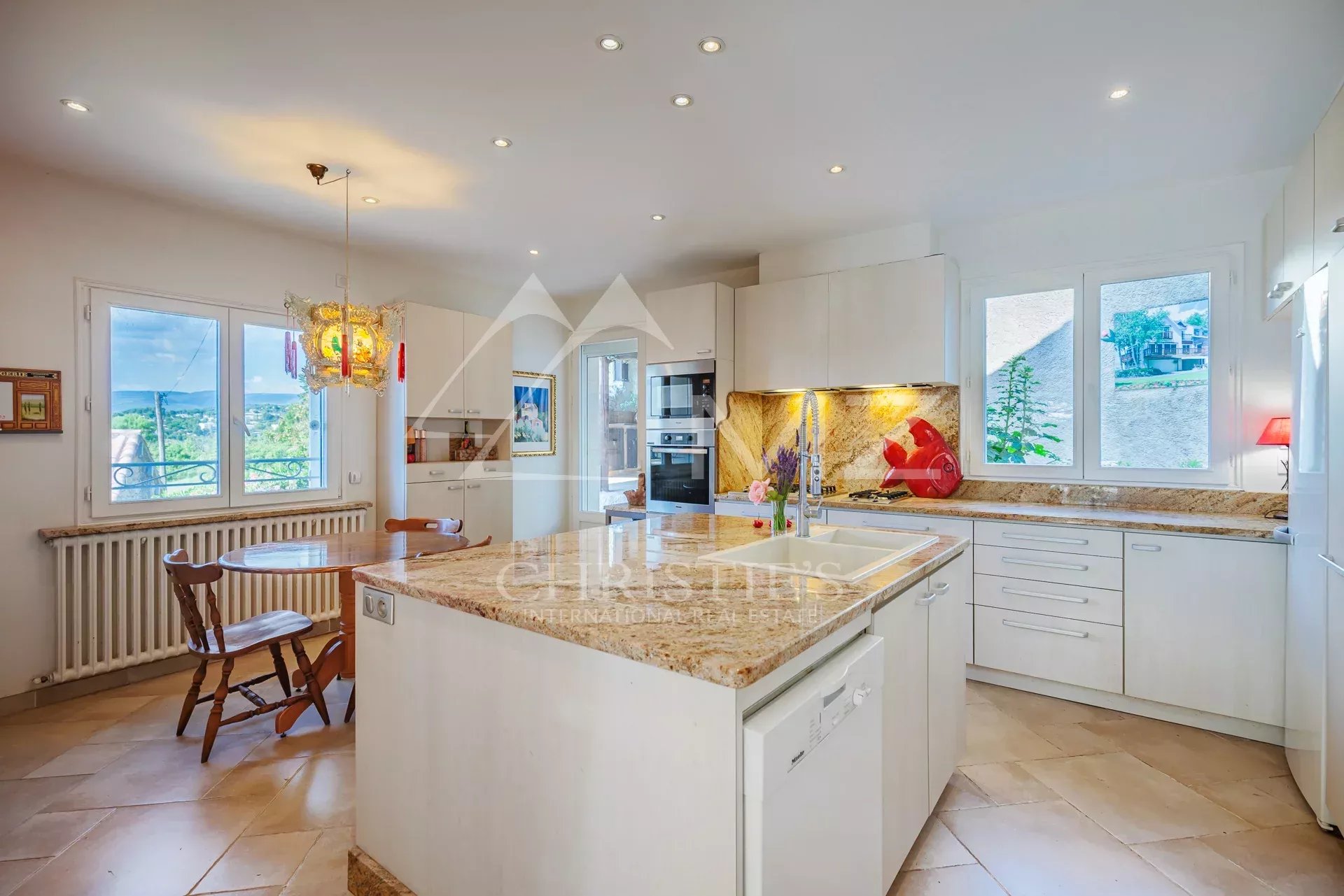 Cuisine spacieuse et lumineuse Cuisine moderne dans une maison spacieuse avec fenêtres offrant une vue sur l'extérieur.