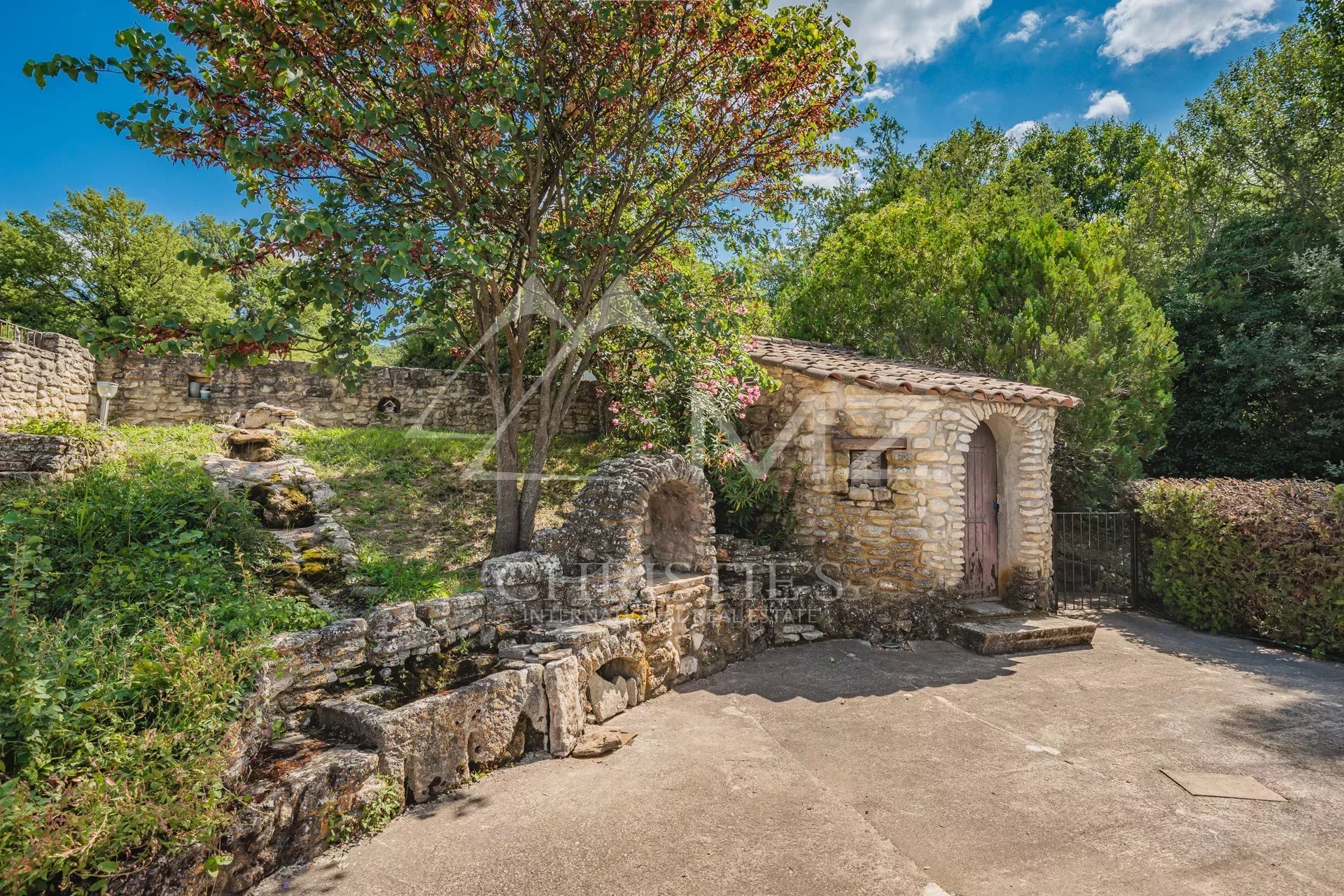 Demeure en pierre avec parc à Apt Bâtiment en pierre dans un parc paysagé avec arbres et verdure, près d'Apt.