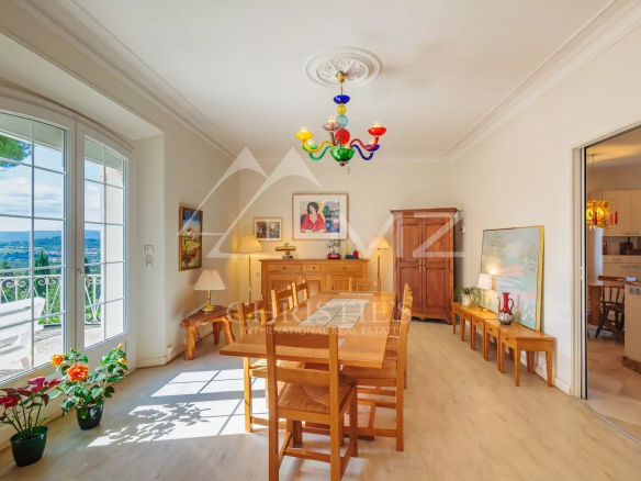 Intérieur d'une maison avec salle à manger lumineuse et vue sur les collines