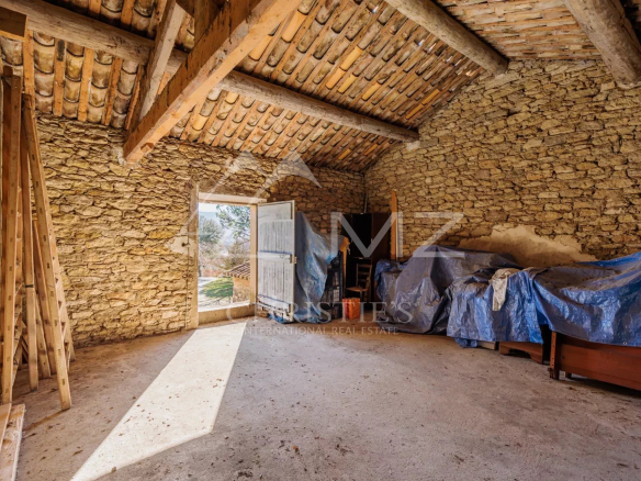 Intérieur d'une ancienne ferme du XIXe siècle à rénover, avec vue sur la nature.