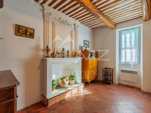 Intérieur d'un mas du XIXe siècle à rénover, avec poutres apparentes et cheminée, à Gordes.