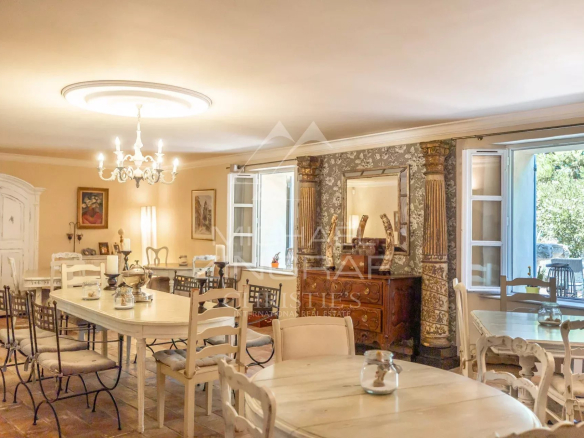 Intérieur d'un ancien prieuré avec tables et chaises dans un cadre provençal.