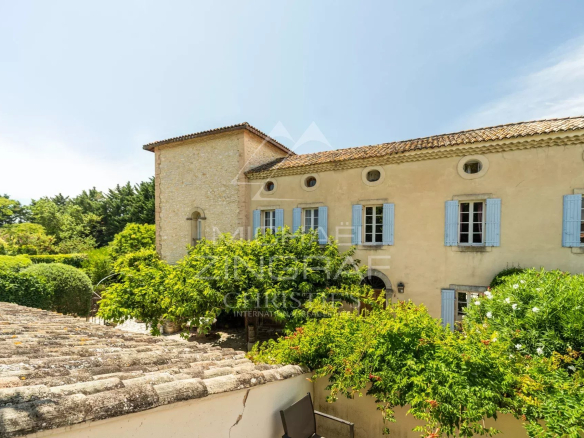 Vue d'un ancien prieuré du XIVe siècle avec jardin et piscine à L'Isle-sur-la-Sorgue.