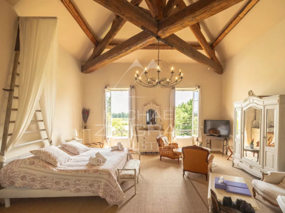 Chambre spacieuse avec plafond en bois et vue sur le jardin dans un ancien prieuré
