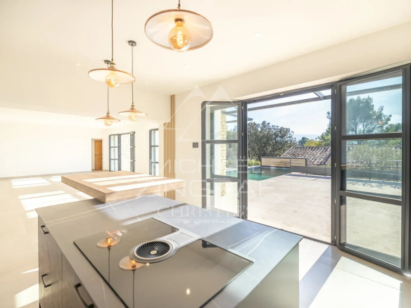 Interior of a contemporary villa in Gordes with large windows and a modern kitchen.
