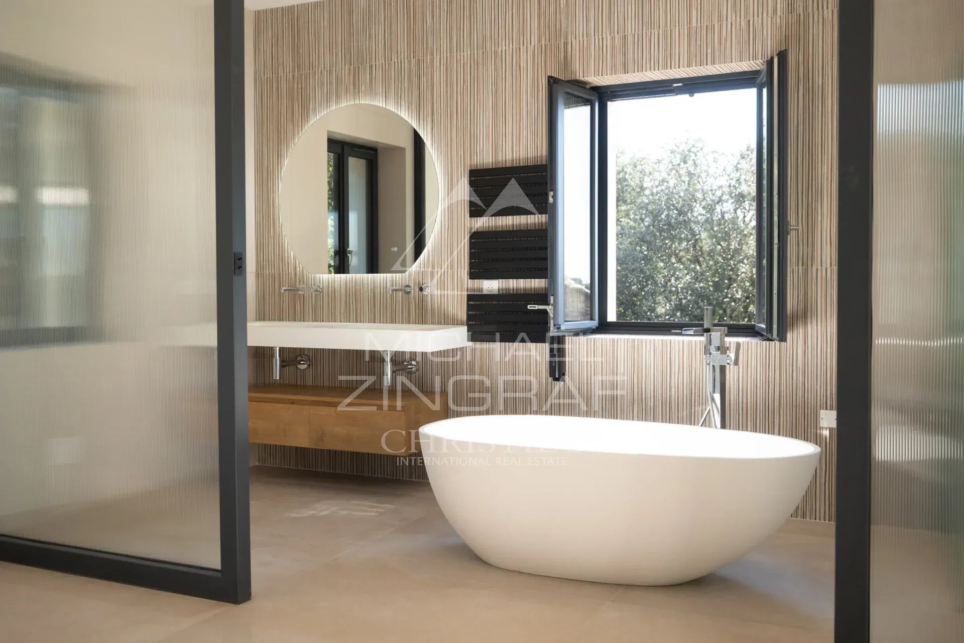 Contemporary bathroom Modern bathroom with freestanding bathtub and window offering a view of nature.