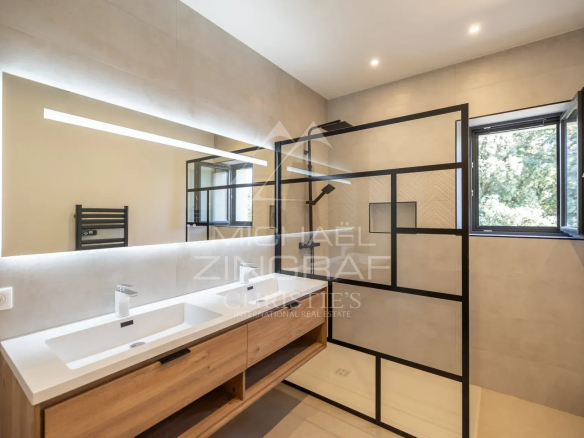 Modern bathroom with walk-in shower and wooden furniture in Gordes.