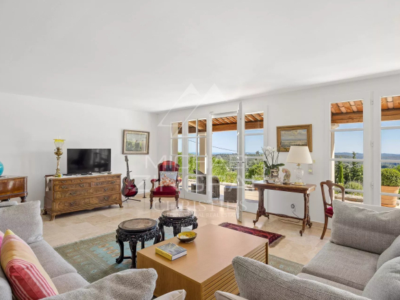 Intérieur d'une villa provençale à Vence avec salon lumineux et vue sur les collines.
