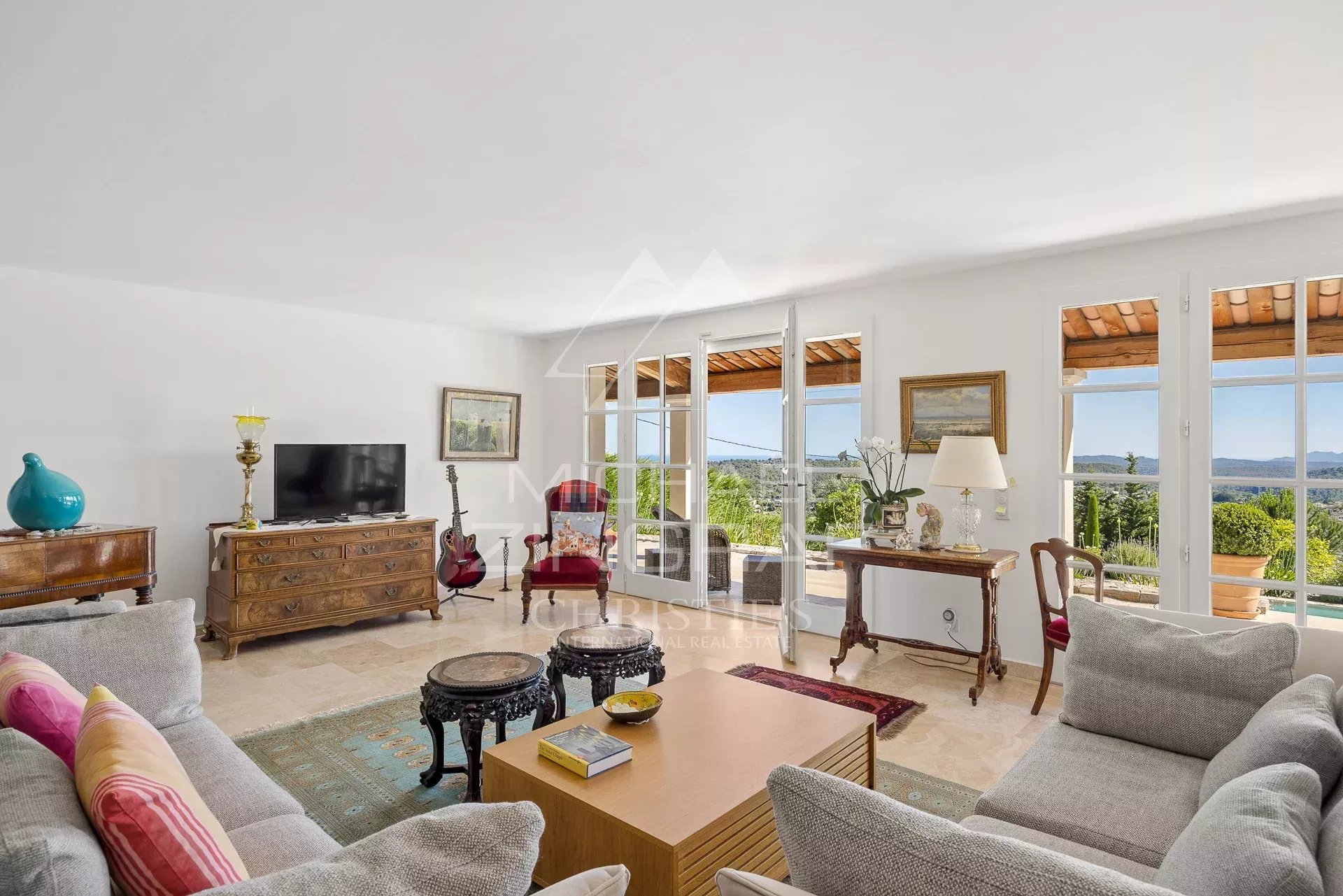 Salon d’une villa provençale à Vence Intérieur d'une villa provençale à Vence avec salon lumineux et vue sur les collines.