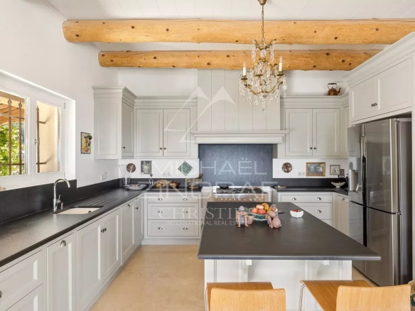 Cuisine d'une villa provençale à Vence avec des poutres en bois et un îlot central